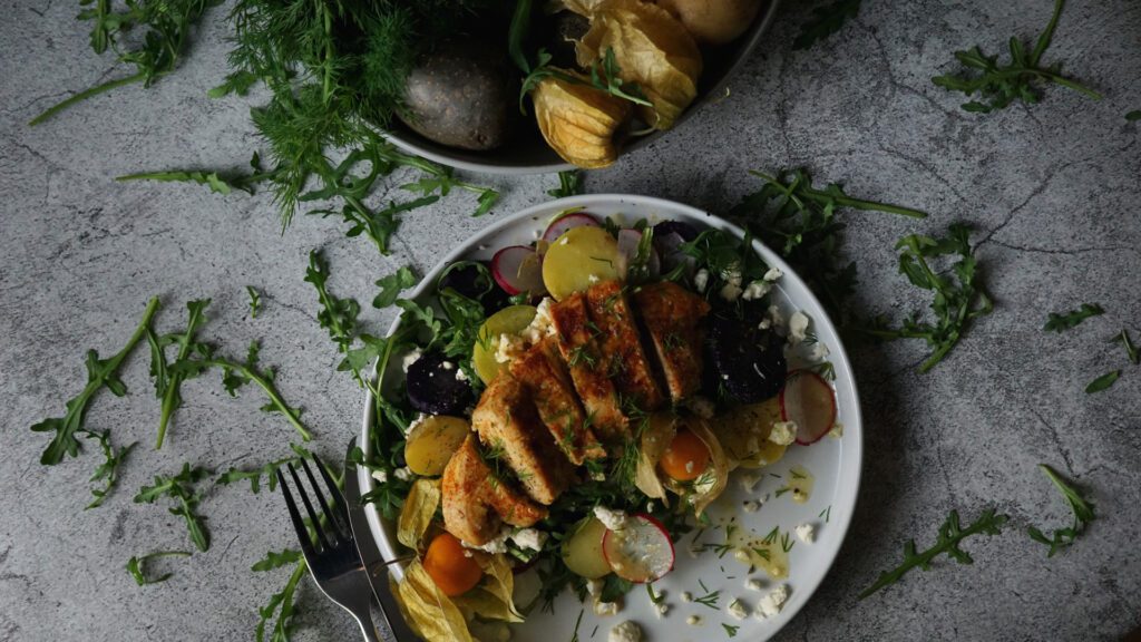 Haehnchen auf Kartoffel-Rucola-Salat mit Orangen-Dressing