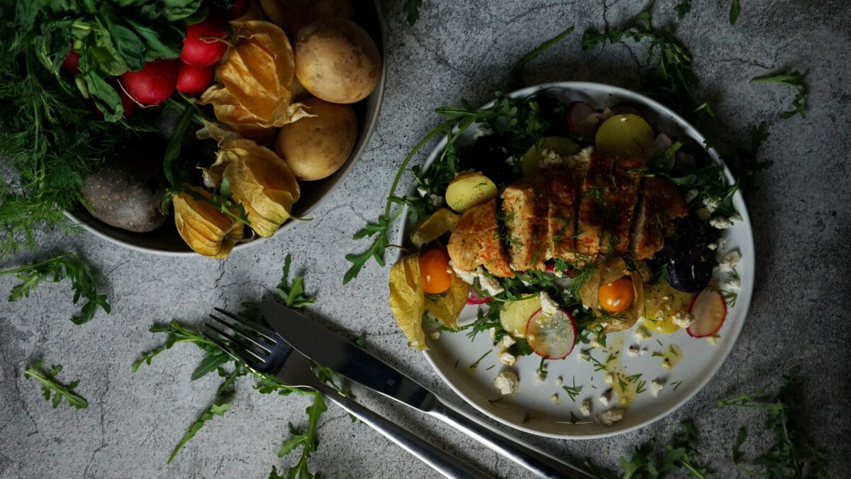 Haehnchen auf Kartoffel-Rucola-Salat mit Orangen-Dressing, Dill, Radieschen und Gurken