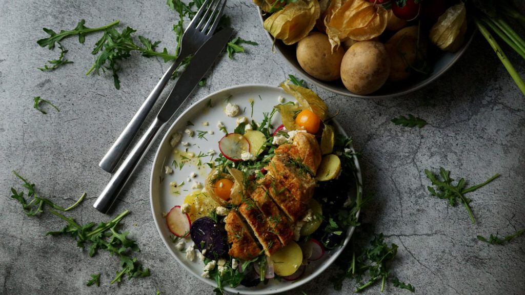 Haehnchen auf Kartoffel-Rucola-Salat mit Orangen-Dressing