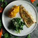 Forellenfilet mit Blattspinat und Kürbispüree fotografiert von oben