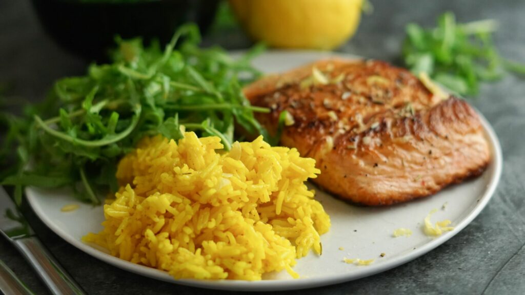 Zitronenreis mit Kurkuma, Lachs und frischem Rucola-Salat