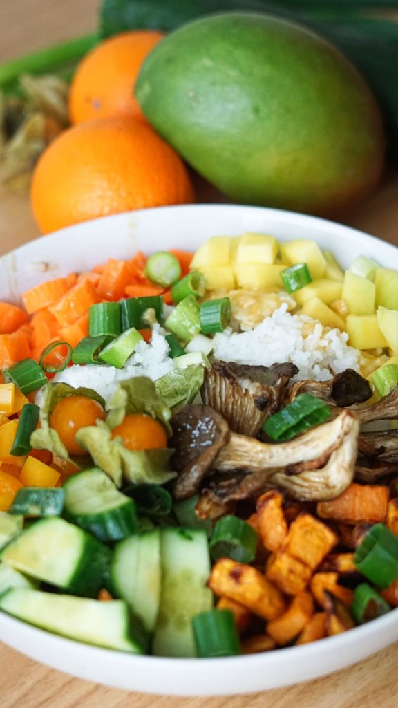 Vegetarische Bowl mit Süßkartoffel, Mango, Gurke, Reis uvm.